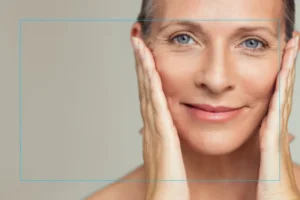 Close up of a woman smiling with her hands on either side of her face
