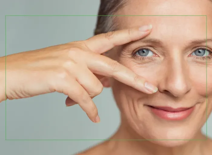 Woman over 40 gently framing her eyes with her hand, highlighting age-related vision changes and eye health concerns.