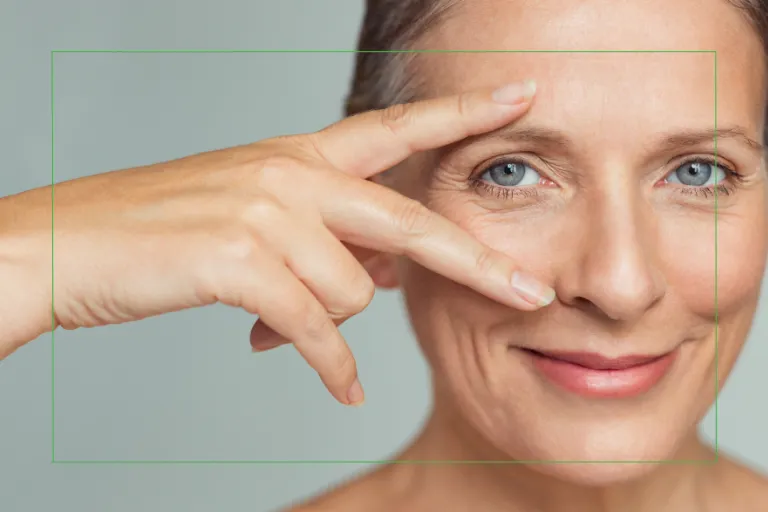 Woman over 40 gently framing her eyes with her hand, highlighting age-related vision changes and eye health concerns.