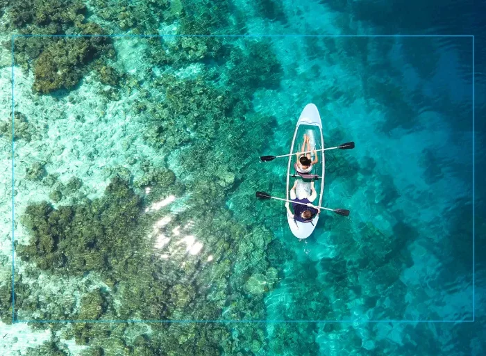 Overhead view of people paddleboarding in clear ocean water, highlighting how LASIK vision correction supports active lifestyles, sports, and outdoor fitness.