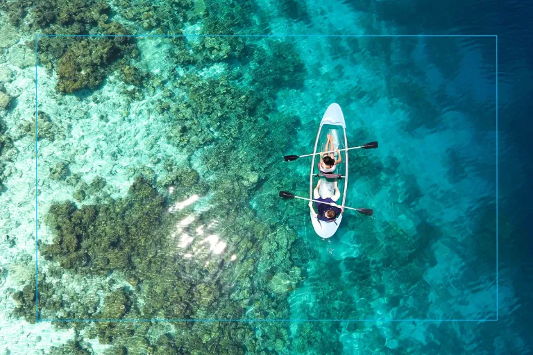 Overhead view of people paddleboarding in clear ocean water, highlighting how LASIK vision correction supports active lifestyles, sports, and outdoor fitness.